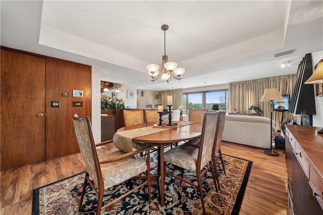 257 Penhurst Dr, Wilkins Twp, PA 15235 - dining room with a raised ceiling, light wood-type flooring, and a chandelier