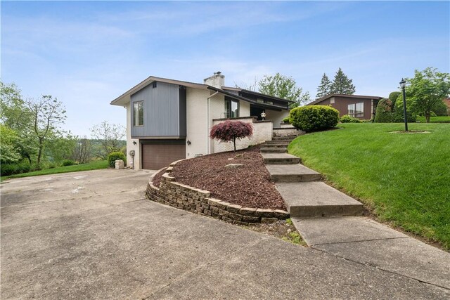257 Penhurst Dr, Wilkins Twp, PA 15235 - view of front of house with a chimney, concrete driveway, an attached garage, and a front lawn