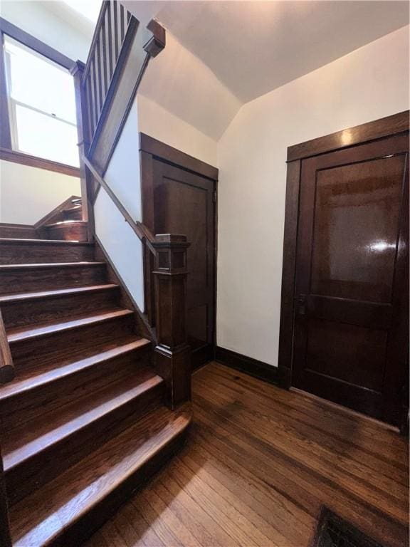 foyer featuring stairs, dark wood-type flooring, vaulted ceiling, and baseboards