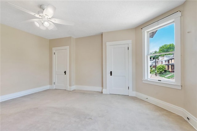 unfurnished room with light carpet, plenty of natural light, and baseboards