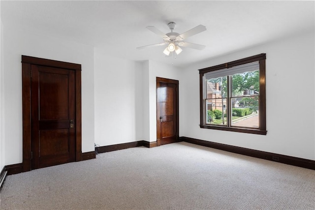 empty room with carpet flooring, baseboards, and ceiling fan