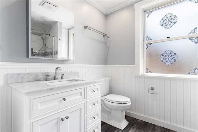 full bathroom with a wainscoted wall, vanity, wood finished floors, toilet, and a shower