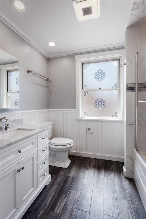 full bath with wood finished floors, toilet, wainscoting, vanity, and recessed lighting