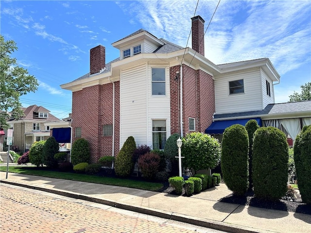 view of home's exterior featuring a chimney and brick siding