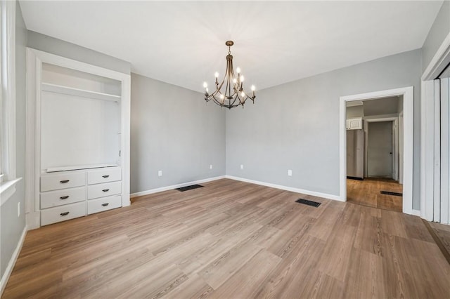 241 Gertrude St, Latrobe, PA 15650 - unfurnished dining area with a chandelier, light wood-type flooring, and baseboards