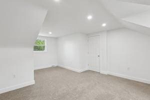 additional living space with recessed lighting, baseboards, carpet floors, and vaulted ceiling