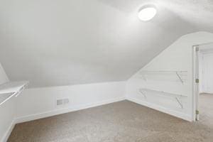 bonus room featuring vaulted ceiling, carpet flooring, and baseboards