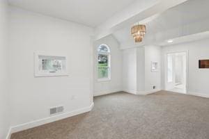 spare room with baseboards, lofted ceiling, carpet flooring, and a chandelier
