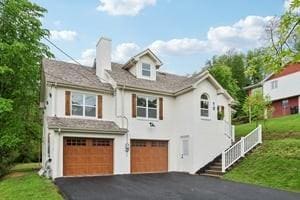 view of front of property featuring a garage, asphalt driveway, a chimney, stucco siding, and a front lawn