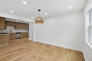 kitchen with dishwasher, recessed lighting, light wood-style floors, light countertops, and baseboards