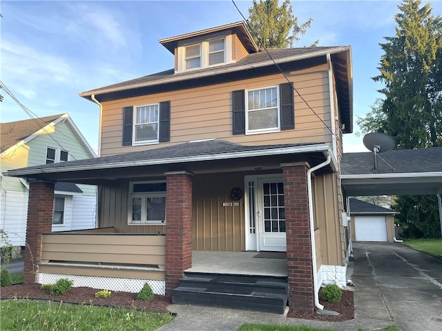traditional style home with a porch, driveway, an outdoor structure, and board and batten siding