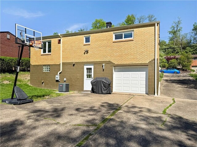 550 Brushglen Ln, Pleasant Hills, PA 15236 - back of house with an attached garage, central air condition unit, brick siding, and driveway
