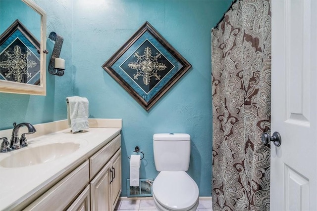 full bath with toilet, vanity, and tile patterned floors