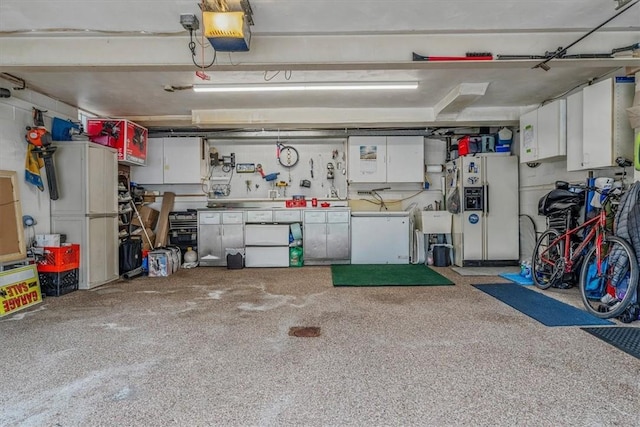 garage with white refrigerator with ice dispenser, a garage door opener, freestanding refrigerator, and washer / clothes dryer