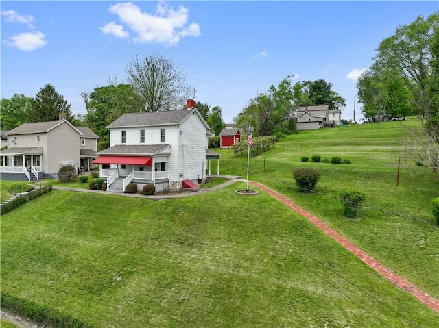 rear view of property featuring a chimney and a yard