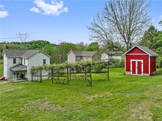 view of green lawn with an outdoor structure and a storage unit