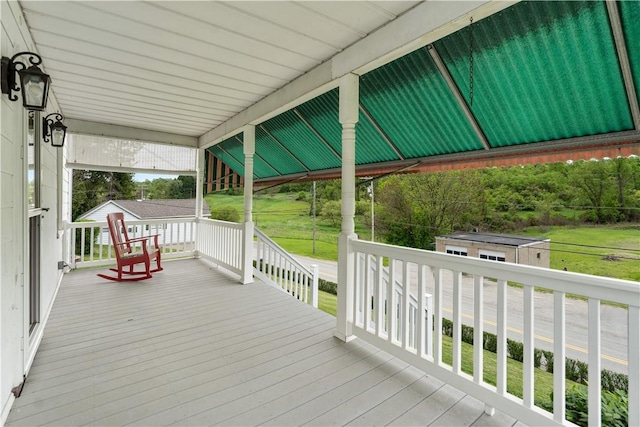 wooden deck with a porch and an outdoor structure