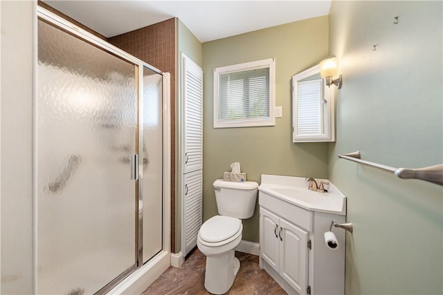bathroom featuring a shower stall, vanity, and toilet