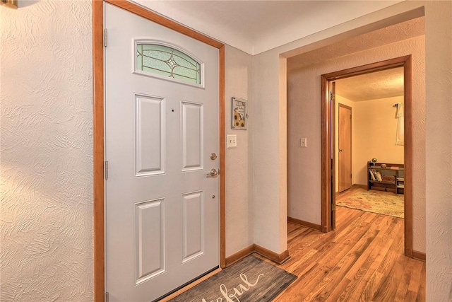 entrance foyer with light wood finished floors and baseboards