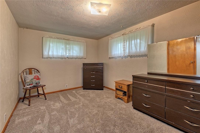carpeted bedroom with a textured ceiling and baseboards