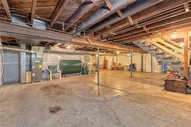 unfinished basement with oil tank, stairs, and heating unit