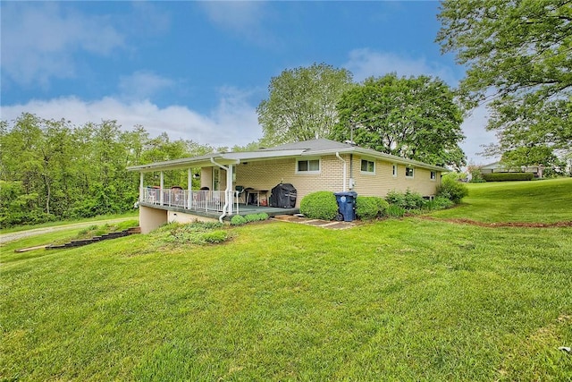 back of property featuring a yard and covered porch