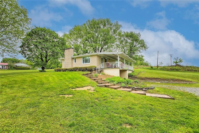 rear view of property featuring a lawn and a chimney