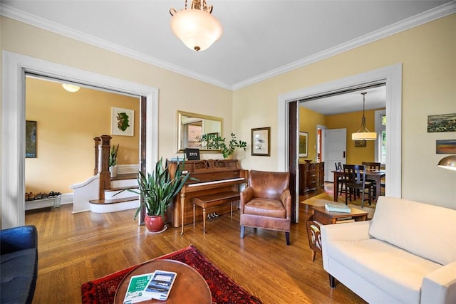 living area with wood finished floors and crown molding
