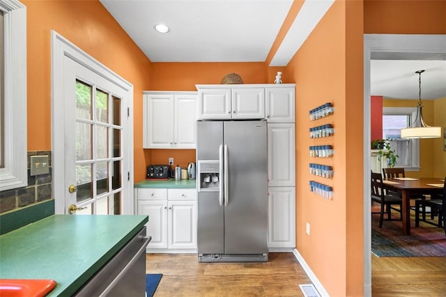 kitchen with appliances with stainless steel finishes, light wood finished floors, white cabinetry, recessed lighting, and pendant lighting