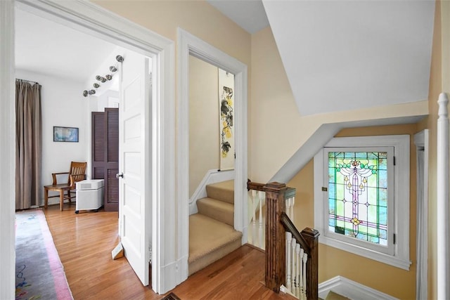 staircase featuring wood finished floors and baseboards