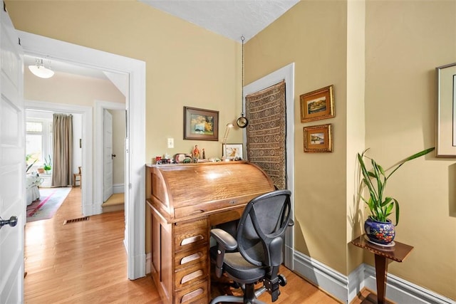 office with light wood-style floors and baseboards