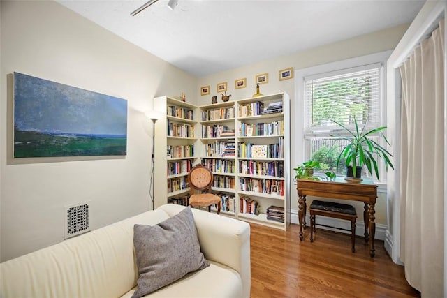 sitting room with wood finished floors and a baseboard radiator
