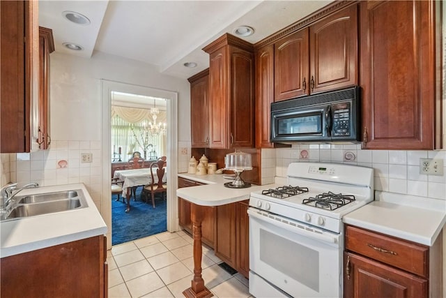 kitchen featuring black microwave, white gas stove, a sink, a chandelier, and light tile patterned floors