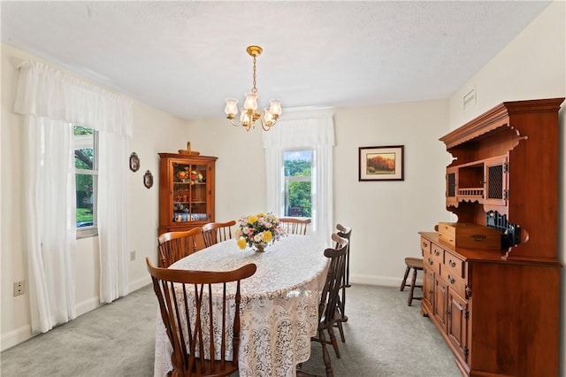 dining room with light carpet, a chandelier, plenty of natural light, and baseboards
