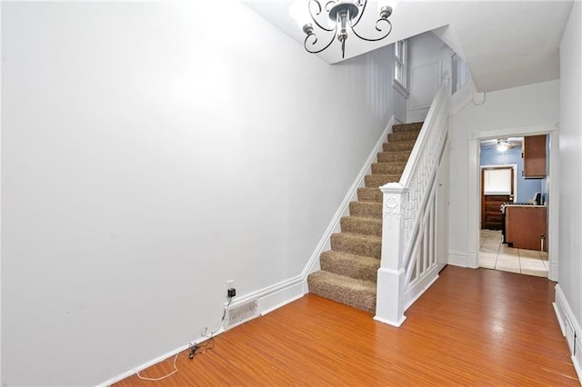 3277 Tuxedo St, Sheraden, PA 15204 - stairs with wood finished floors, a chandelier, and baseboards