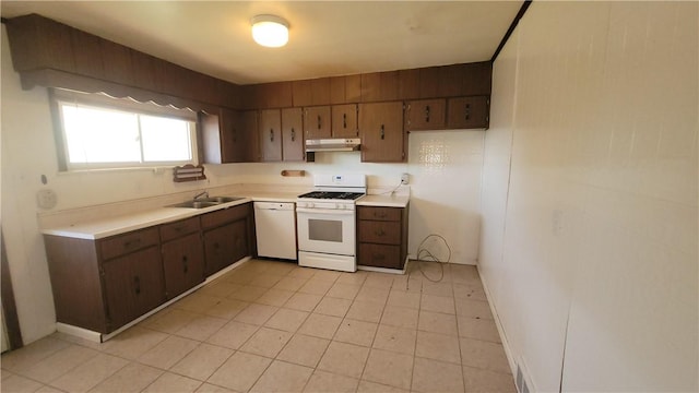 kitchen featuring white appliances, under cabinet range hood, a sink, and light countertops