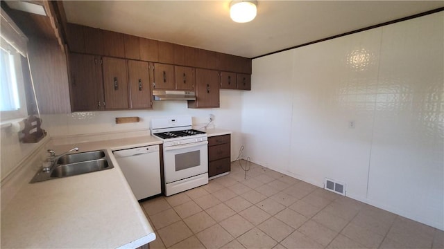kitchen featuring white appliances, under cabinet range hood, a sink, and light countertops