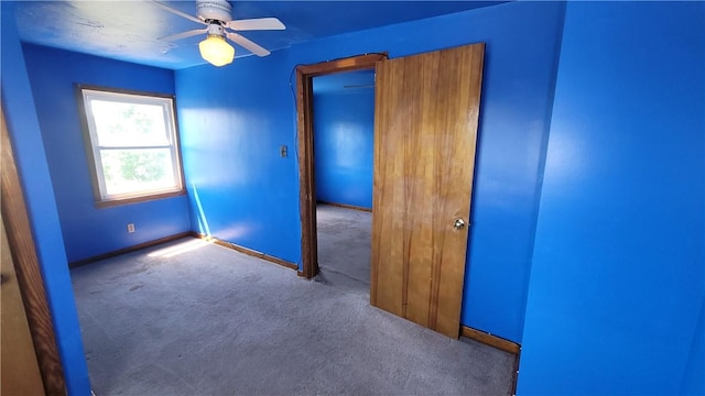 spare room featuring carpet floors, ceiling fan, and baseboards