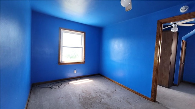 carpeted spare room with baseboards and a smoke detector