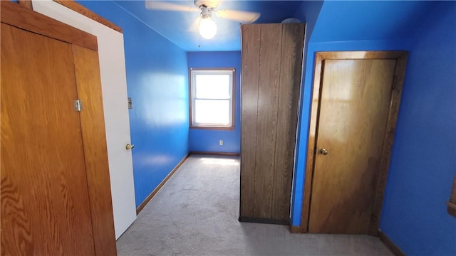 hallway with carpet floors and baseboards