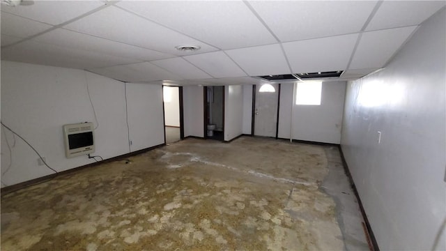below grade area featuring heating unit and a drop ceiling