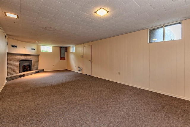 basement with a brick fireplace, carpet floors, and electric panel
