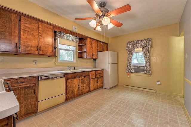 kitchen with dishwashing machine, baseboard heating, freestanding refrigerator, a sink, and light flooring