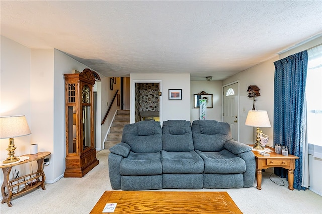 carpeted living area with stairs, a textured ceiling, and baseboards