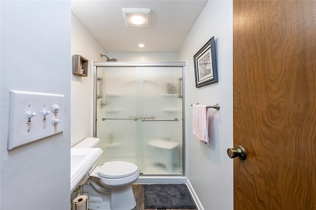 full bath with a shower stall, toilet, and baseboards
