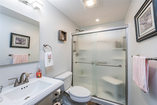bathroom featuring a sink, a stall shower, toilet, and recessed lighting