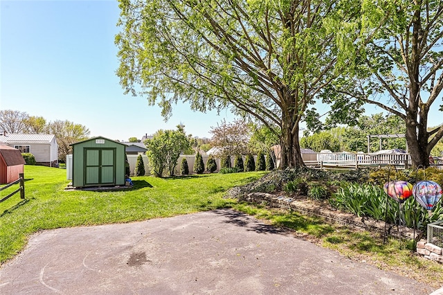 view of green lawn featuring a shed and an outbuilding
