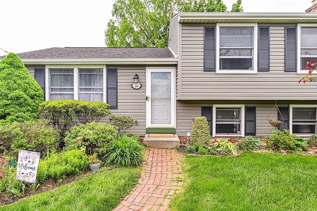 split level home featuring a front lawn and entry steps