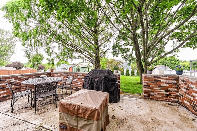 view of patio / terrace featuring outdoor dining space, an outdoor structure, a storage shed, and fence