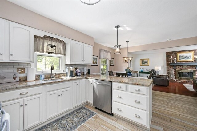 9204 Douglas Fir Dr, Plum Boro, PA 15239 - kitchen with stainless steel dishwasher, a sink, a peninsula, light wood finished floors, and tasteful backsplash